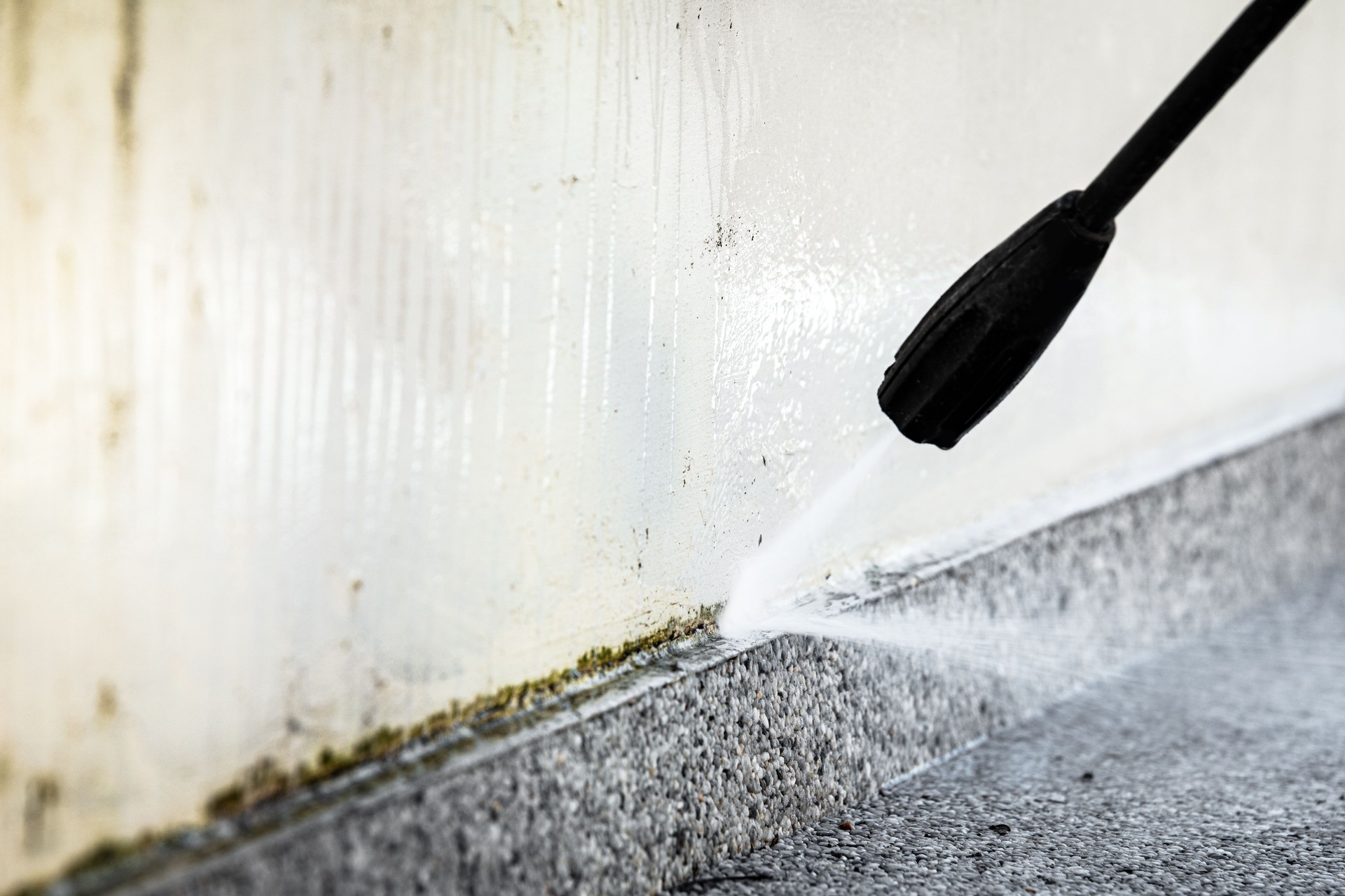 cleaning of a concrete wall with a high pressure cleaner, close up